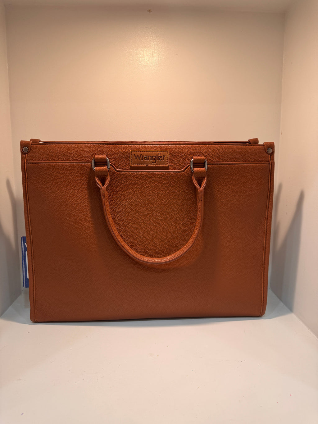 Brown leather briefcase with visible brand logo on a white background